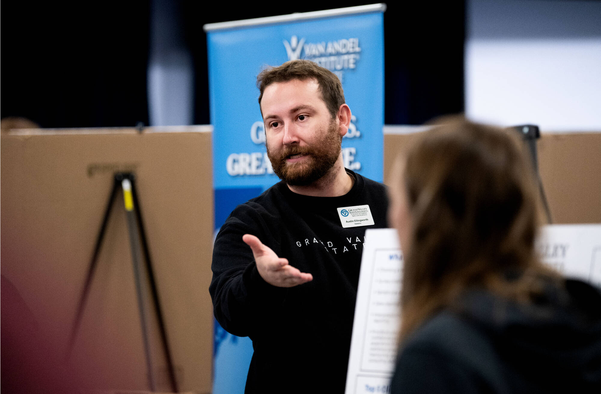 Austin Ellingworth, assistant professor of statistics, greets students during the Undergraduate Research Fair help at the Grand River Room.